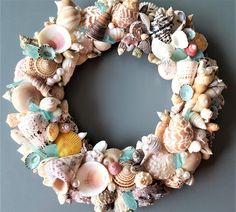 a wreath made out of seashells and other sea creatures on a gray background