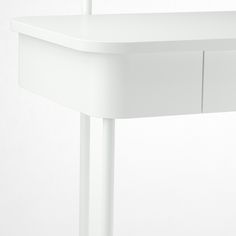 a white desk with two drawers and a pen sticking out of it's drawer