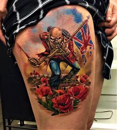 a man's thigh with a tattoo on it that has an image of a skeleton holding