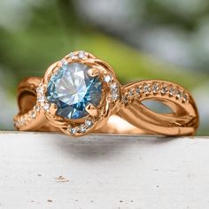 a blue diamond ring sitting on top of a table