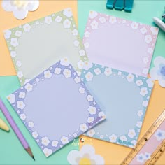 three different colored papers with flowers on them and pencils next to one another near a ruler