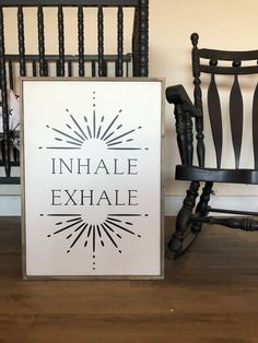 an inhale exhale sign sitting next to a rocking chair