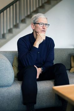 a man sitting on top of a couch next to a stair case