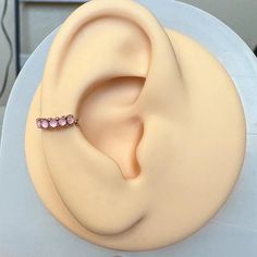 a pink ear ring sitting on top of a white cake