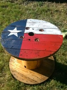 a round wooden table with an american flag painted on it and two holes in the middle