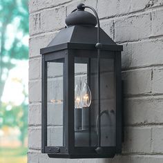 an outdoor light on the side of a brick wall with two lights attached to it