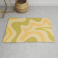 a yellow and green rug on the floor next to a basket with a plant in it