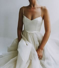 a woman in a white dress sitting down