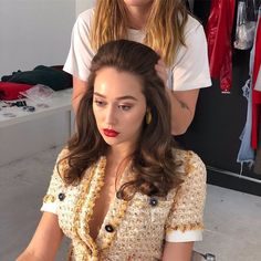 a woman getting her hair styled by another woman