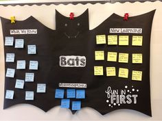 a bulletin board with lots of sticky notes attached to it and bats on the wall