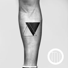 a black and white photo of a person's leg with a triangle tattoo on it