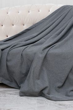 a white couch with a gray blanket on it