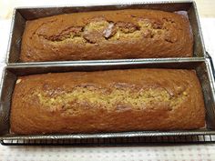 two loafs of banana bread sitting on top of a metal pan next to each other