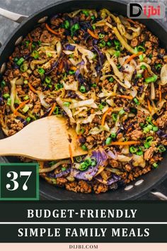 a large skillet filled with meat and vegetables on top of a table next to a wooden spoon