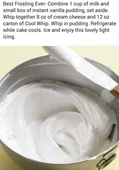 a bowl filled with white cream sitting on top of a table next to a knife