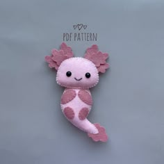 a pink and white stuffed animal with hearts on it's tail, sitting against a gray background