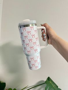 a person holding a coffee cup with bows on it