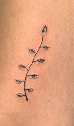 a small tattoo on the back of a woman's lower thigh, with a single flower