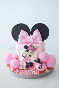 a minnie mouse cake with pink and white decorations