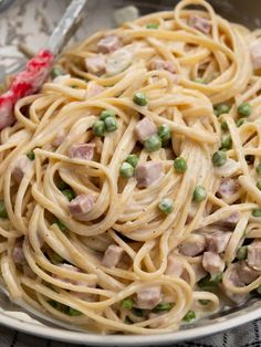 a plate of pasta with peas and ham