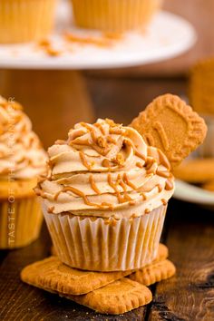 some cupcakes with peanut butter frosting and mickey ears on top are sitting on the table