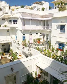 an aerial view of a building with white walls and balconies on the second floor