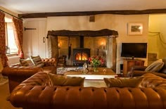 a living room filled with furniture and a fire place in the middle of it's wall