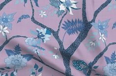 a tree with blue and white flowers on it is in front of a pink background