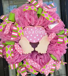 a pink and green wreath that says it's a girl on the front door