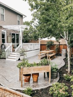 an outdoor patio with benches and potted plants