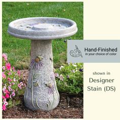 a bird bath sitting in the middle of a garden with flowers around it and an ad for hand - finished in your choice of color