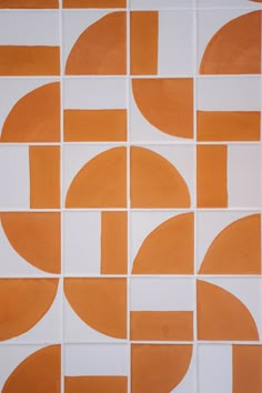 an orange and white tiled wall with circles