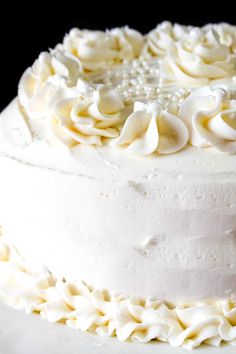 a close up of a cake with white frosting flowers on the top and bottom