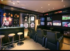 a sports themed home bar with seats and televisions