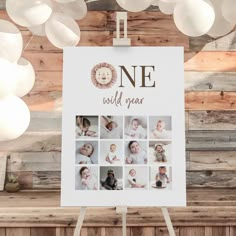 a one year old photo is displayed on a easel with balloons in the background