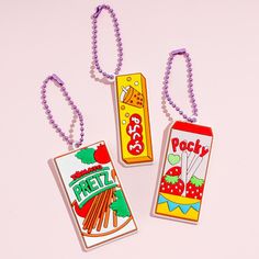 three different colored tags on a pink background with chain attached to each one, and the tag has an image of pretzels in it