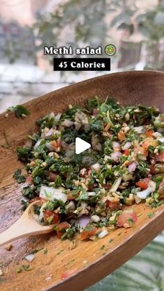 a wooden spoon filled with chopped vegetables on top of a table