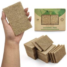 a hand holding up some kind of cardboard coasters next to a box of scouring pads