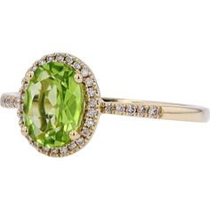 an oval shaped ring with a green stone surrounded by white and yellow diamond halos