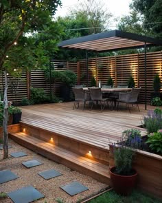 a wooden deck surrounded by plants and lights