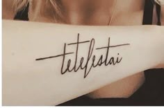 a woman with a tattoo on her arm that says titelfata in cursive writing