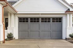 a white house with a gray garage door