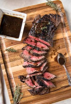 steak on a cutting board with sauce and spoon