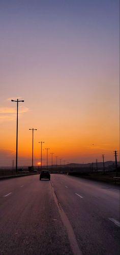 a car driving down the road at sunset