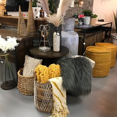 several baskets are arranged on the floor in front of a table with flowers and other decorative items