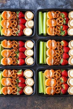 six trays filled with pretzels, strawberries and celery