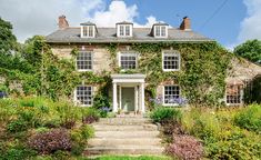 a large house with lots of windows and ivy growing on it's side wall