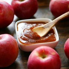 an apple sauce in a small bowl with apples around it