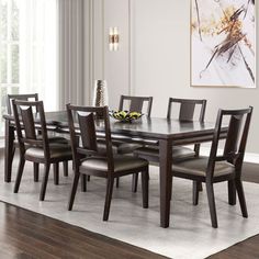 a dining room table and chairs in front of a window