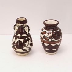 A pair of small Armenian vases, decorated with brown patterns and hand painted flowers over an off-white background, complete with a glossy finish. Measurements Handled Vase- 4" Tall, 2 1/4" Diameter at widest point Open Vase- 3 3/4" Tall, 2 3/8" Diameter at widest point Pre owned, there are smudges on pattern beneath the finish of both pieces, and a small chip on the top of one of the vases.   Ships Same Or One Day , upon payment  Tracking number & Delivery Confirmation All items I sell are marked with an invisible UV identifier To confirm originality of the item To prevent condition issues / return fraud Buy With Confidence Check out our feedback ! Biblical Flowers, Ceramic Pottery Vase, Ceramics Pottery Vase, Handle Vase, Hand Painted Flowers, Painted Flowers, Pottery Vase, Ceramic Pottery, Tracking Number